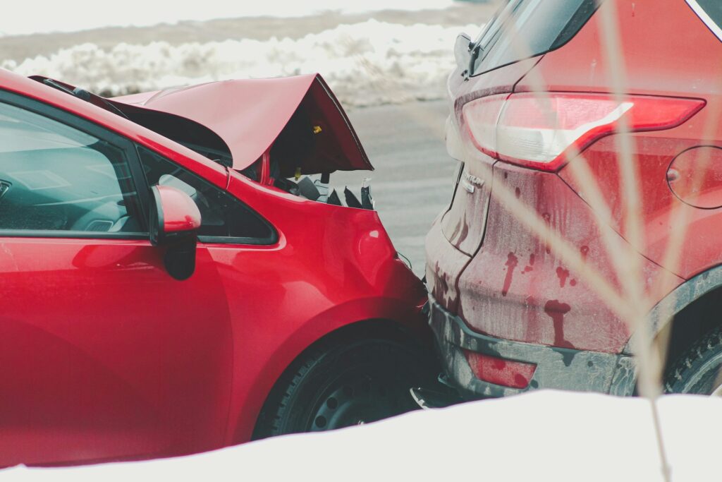 A damaged red car is partially buried in snow, highlighting the aftermath of a hit-and-run accident in Houston.