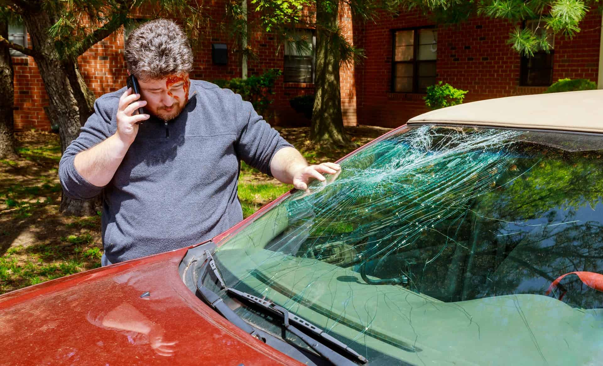 A man converses on a cell phone next to a vehicle, related to a rental car accident in Houston.