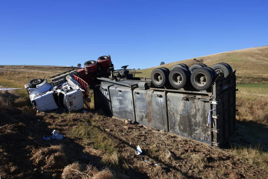 A truck lies upside down on a hill after a highway accident in Houston.