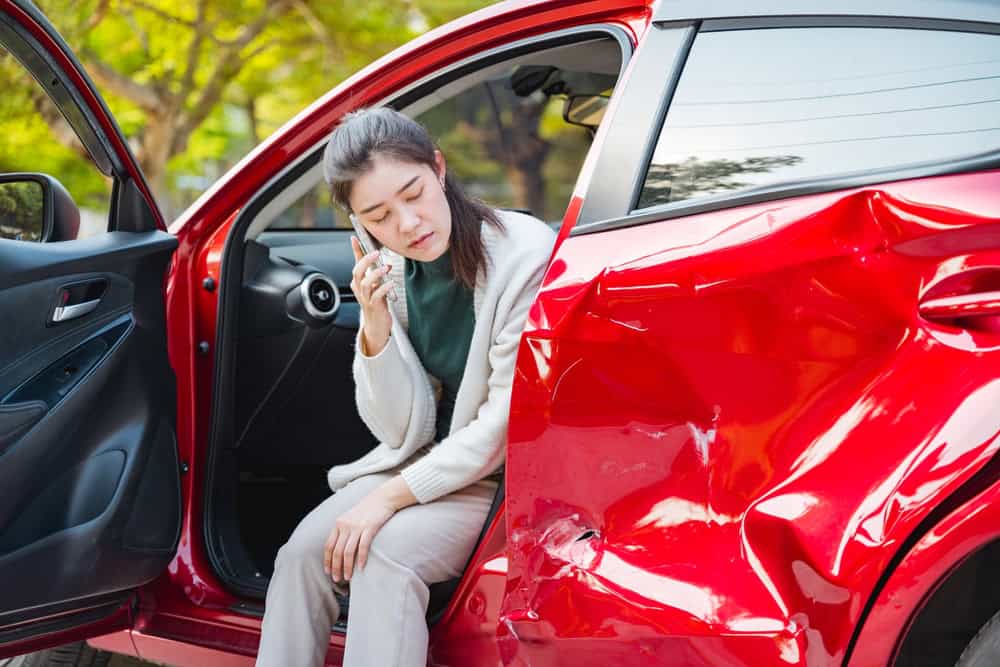 a woman calling her lawyer after being in a car crash